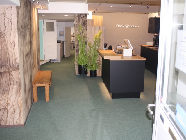 Eingangsbereich von Optik Schink mit Logo an der Wand